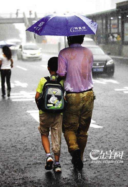前日下午4时40分,一位父亲撑着伞为孩子挡雨,而自己全身上下早已湿透